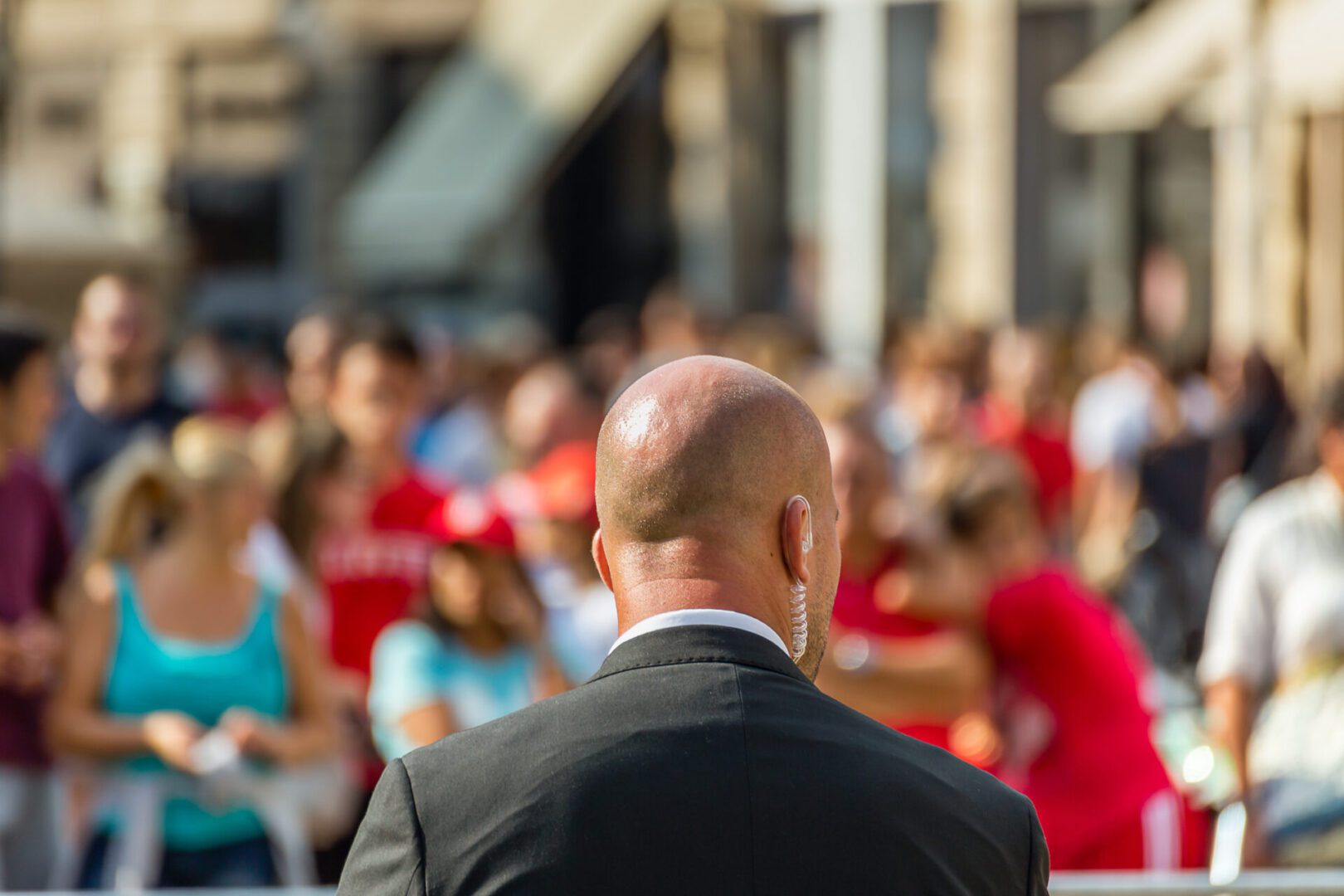 Bald security guard monitoring crowded public event